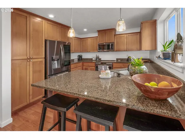 a kitchen with stainless steel appliances granite countertop a sink refrigerator and microwave