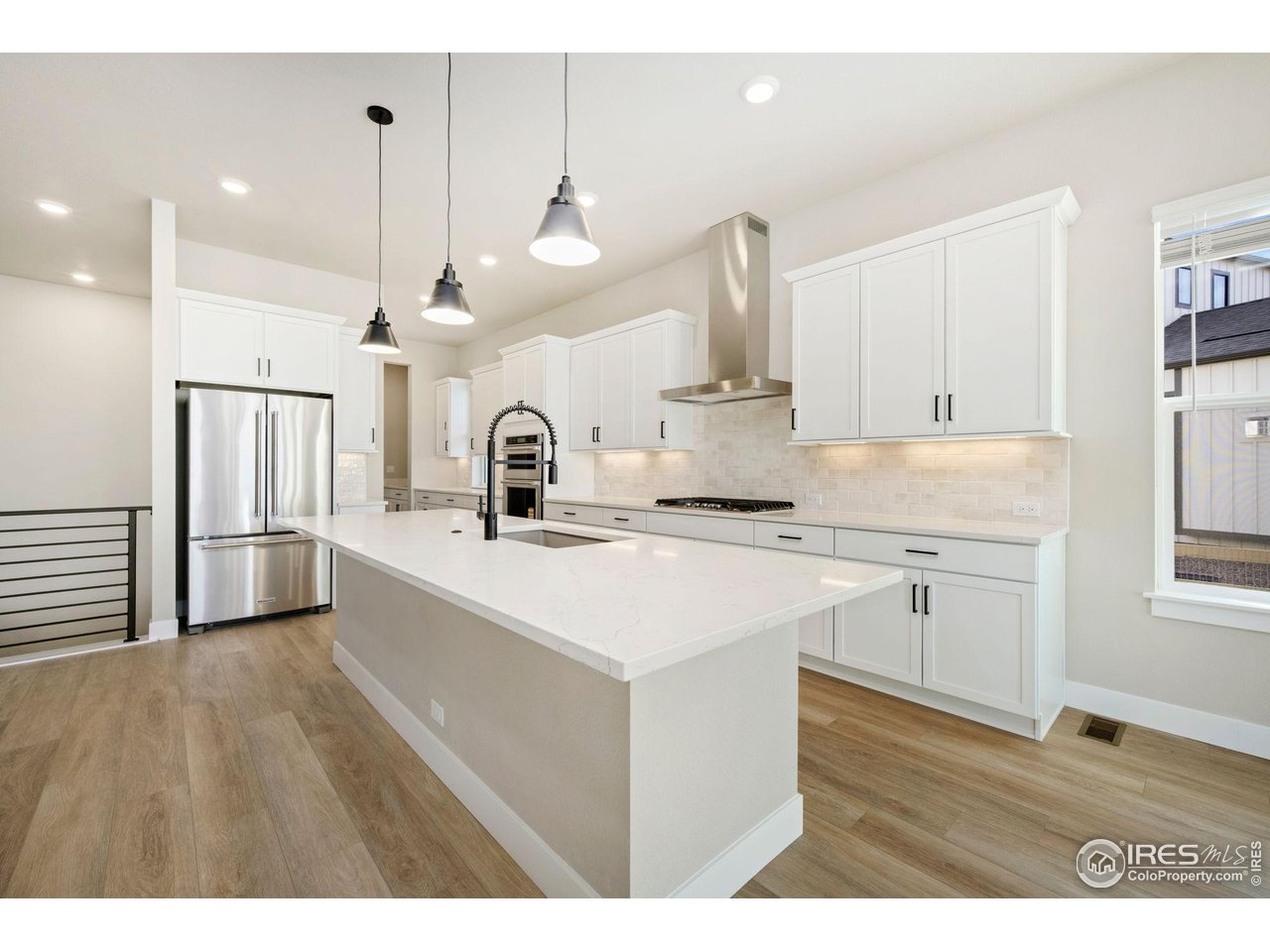 1426 Alyssa Drive Timnath, CO 80547 - Photo 3 of 15 a kitchen with kitchen island a sink stainless steel appliances and cabinets