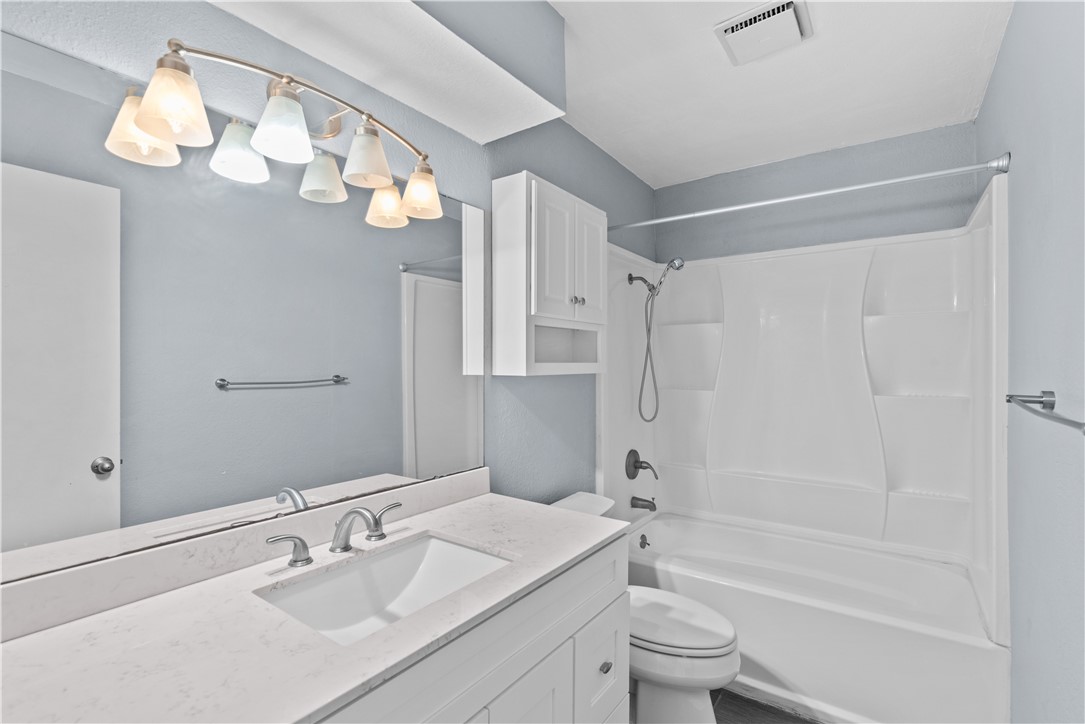 1305 Harbor Lights Drive Corpus Christi, TX 78412 - Photo 17 of 31 a bathroom with a sink a toilet and a mirror