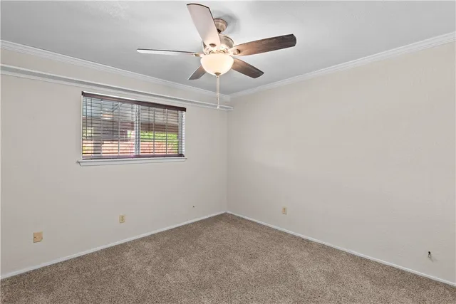 an empty room with ceiling fan and window