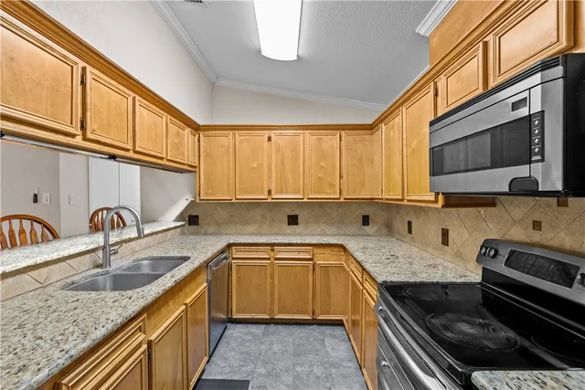 a kitchen with stainless steel appliances granite countertop a sink stove and cabinets
