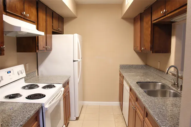 a kitchen with a sink a stove and a refrigerator