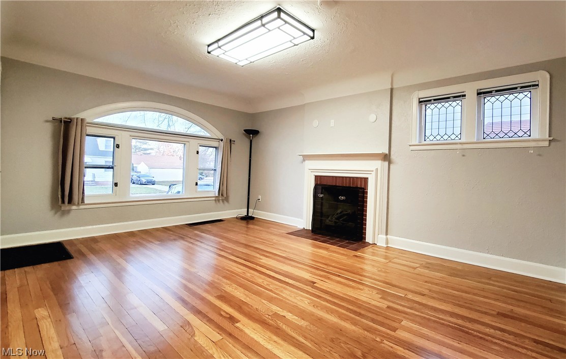 4348 Prasse Road South Euclid, OH 44121 - Photo 4 of 10 Living room featuring a gas fireplace and plenty of natural lighting supplied by the picture window complimented by an arched transom & adjacent double-hungs, plus two leaded-glass windows for additional light & character