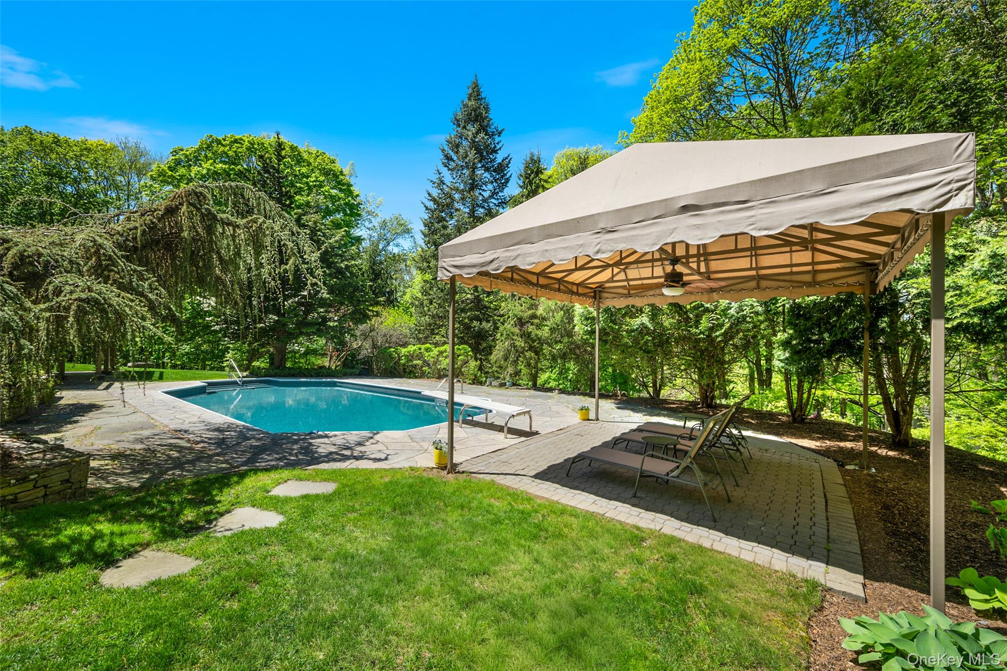 120 Kitchawan Road Pound Ridge, NY 10576 - Photo 4 of 40 a view of a patio with a table and chairs under an umbrella
