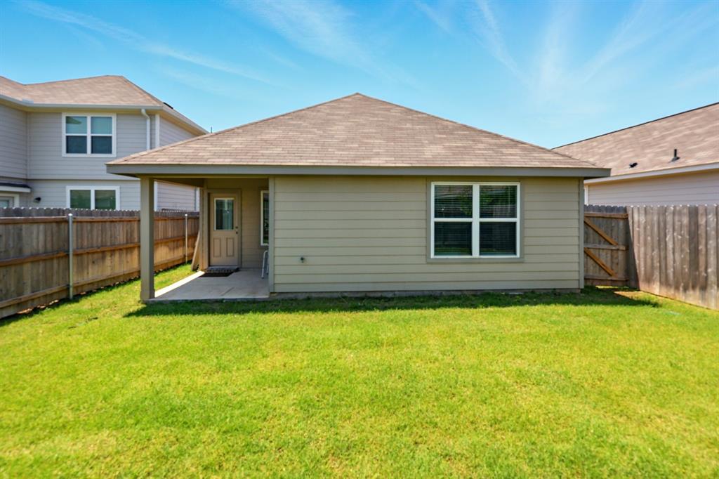 105 Musgrove Road Everman, TX 76140 - Photo 5 of 6 Back of property featuring a patio area, a shingled roof, a fenced backyard, and a gate