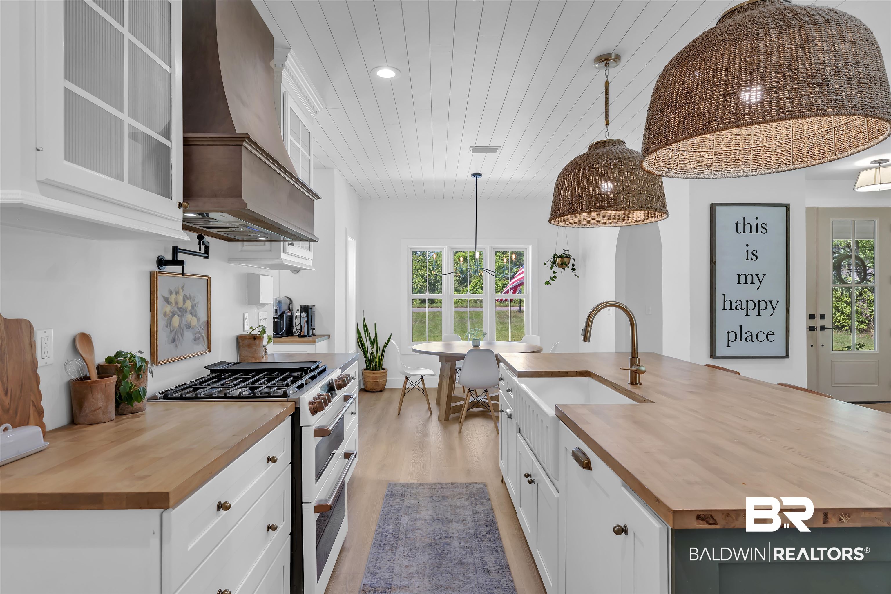 19058 James Road Gulf Shores, AL 36542 - Photo 12 of 49 Kitchen with wooden counters, white cabinetry, range with two ovens, a large island with sink, and decorative light fixtures