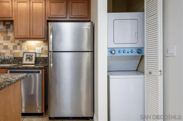 a kitchen with metallic refrigerator and cabinets