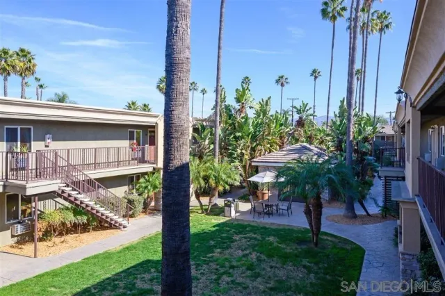 a view of a house with a yard and potted plants