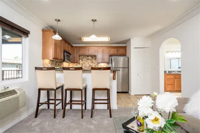 a kitchen with stainless steel appliances kitchen island granite countertop a refrigerator and microwave