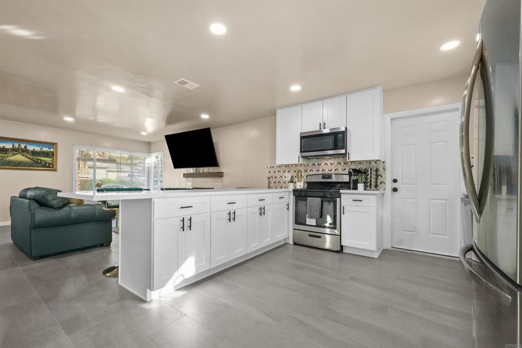 8543 Via Consuelo El Cajon, CA 92021 - Photo 5 of 51 a kitchen with microwave a refrigerator and a stove top oven