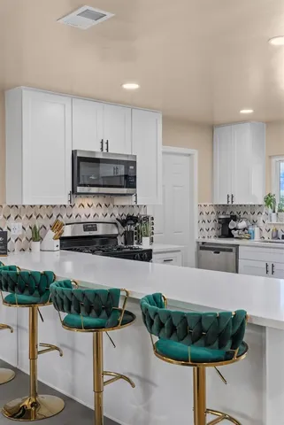 a kitchen with stainless steel appliances kitchen island granite countertop a stove and a sink