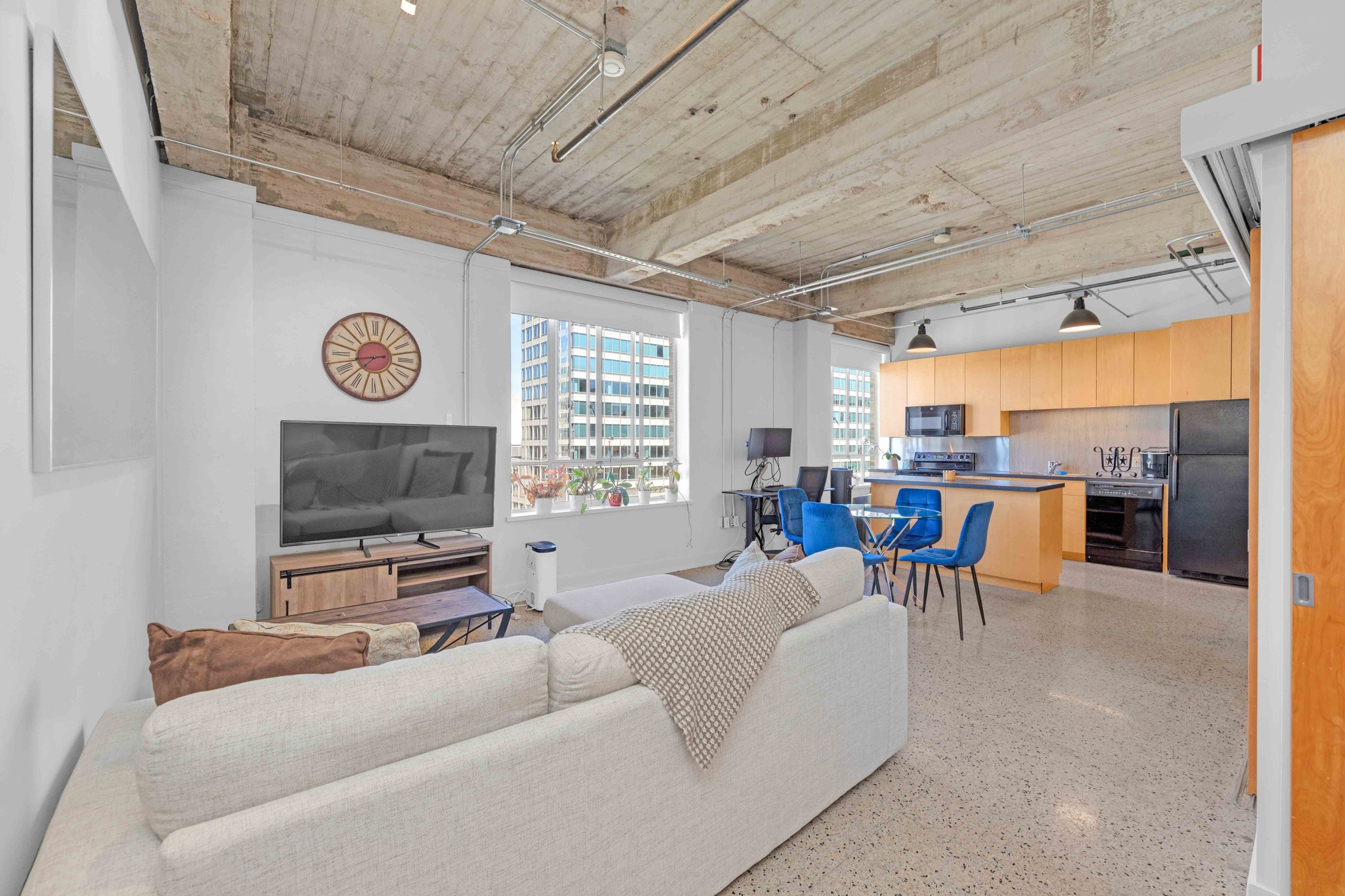 Open living area with kitchen, dining space, and large windows