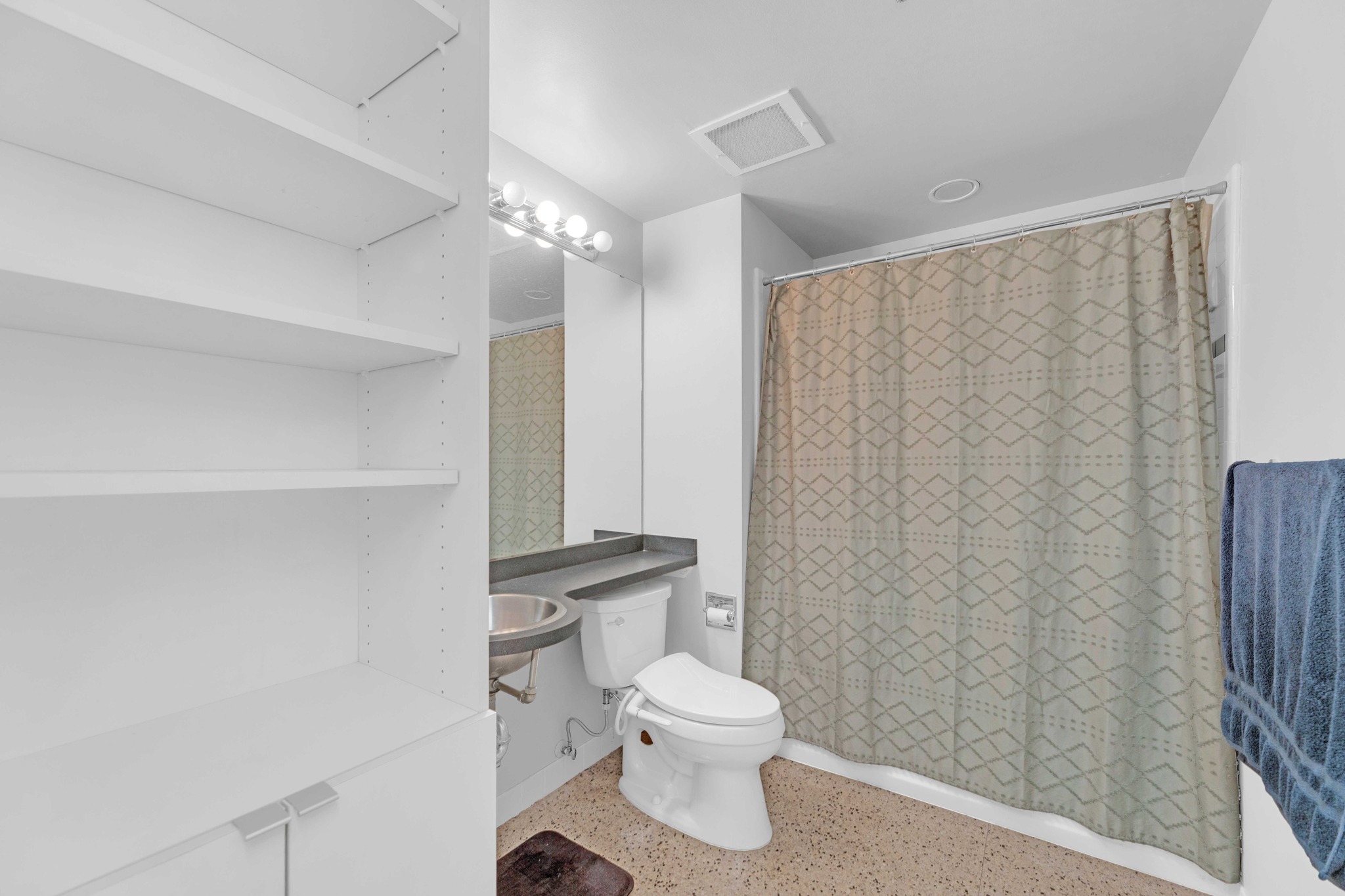 710 Colorado Street, Unit 8C Austin, TX 78701 - Photo 16 of 30 Bathroom with vanity, shelving, and tub/shower combination