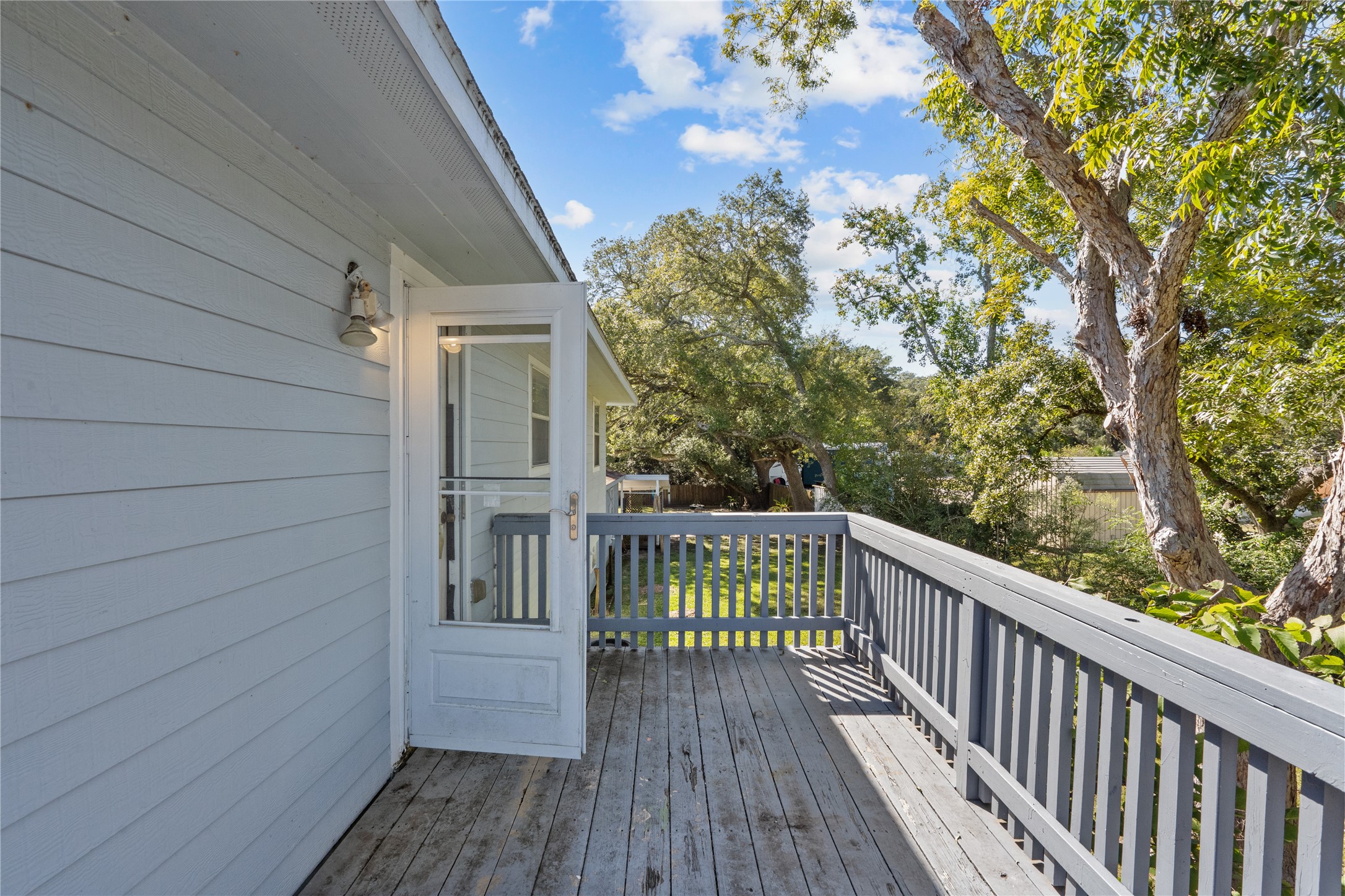 a view of balcony with wooden floor and fence