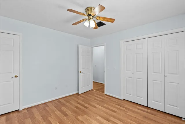 a view of an empty room with window a ceiling fan