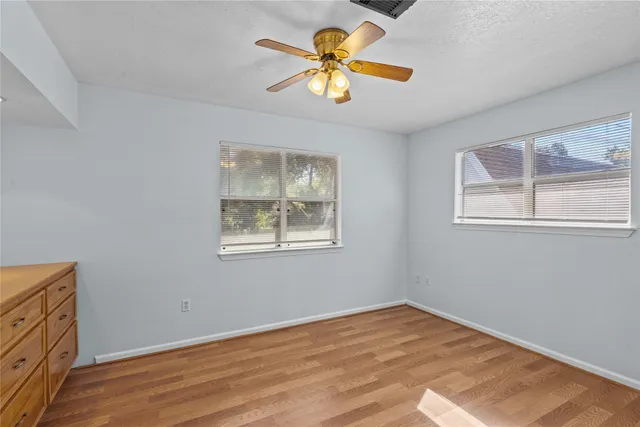 a view of workspace with wooden floor and a window