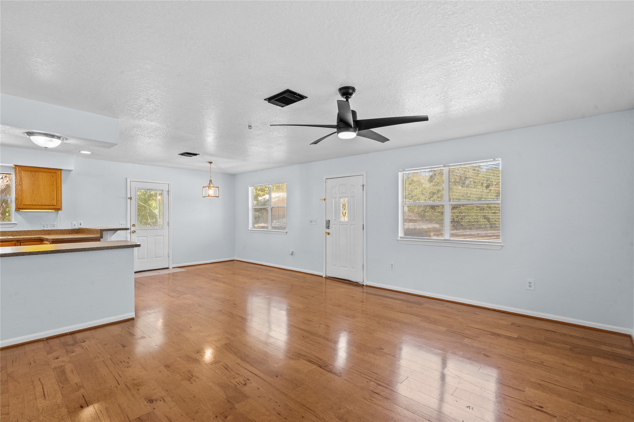 336 Reppert Street, Unit A Bacliff, TX 77518 - Photo 4 of 17 wooden floor in an empty room with a window