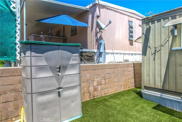 a view of a house with chairs and flower plants