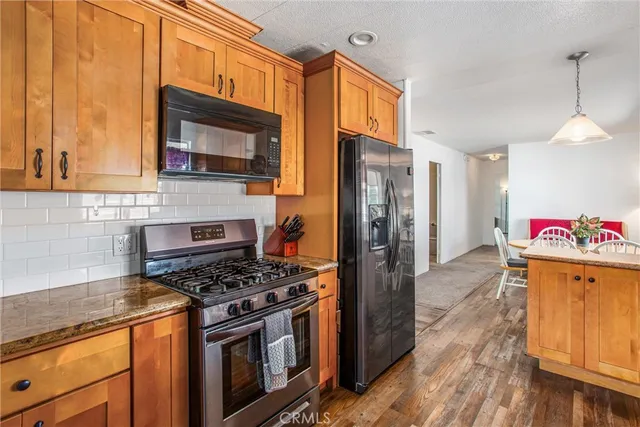a kitchen with stainless steel appliances granite countertop a sink and wooden cabinets