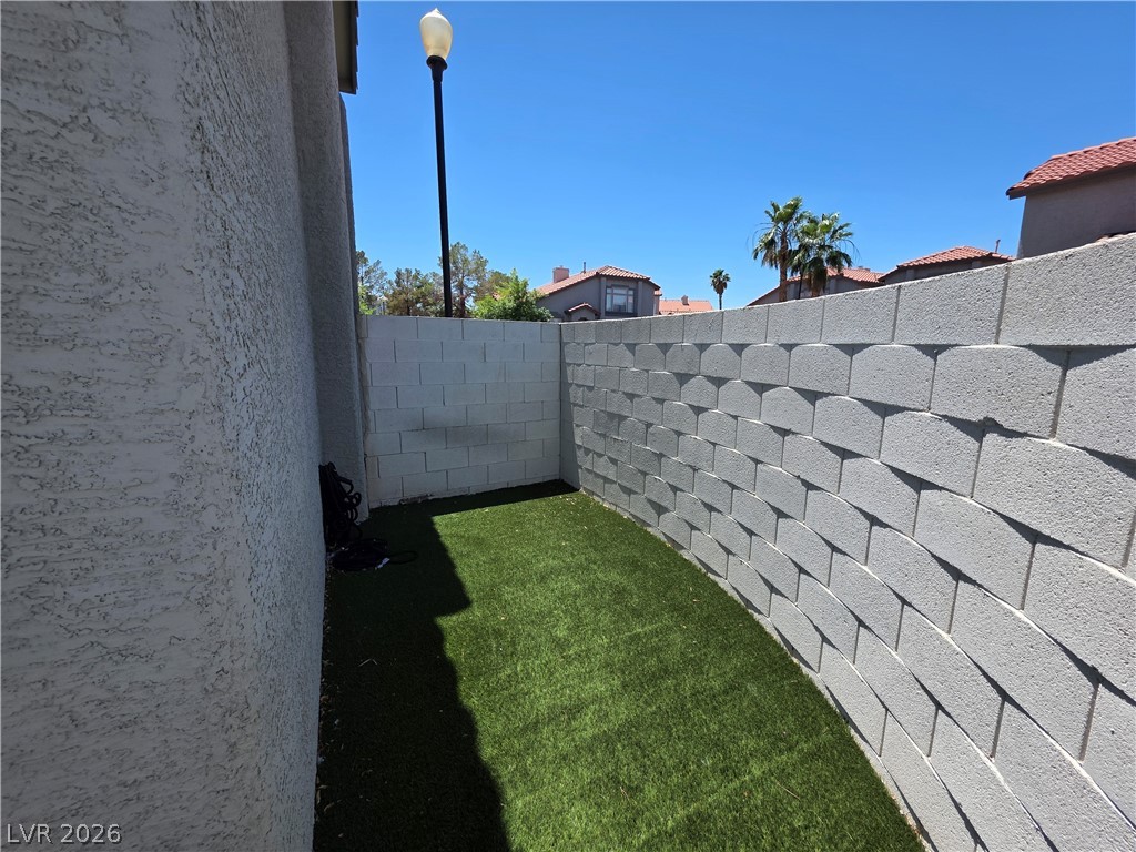 2275 Ramsgate Drive Henderson, NV 89074 - Photo 5 of 84 A compact yard space offers artificial turf and a high privacy wall.