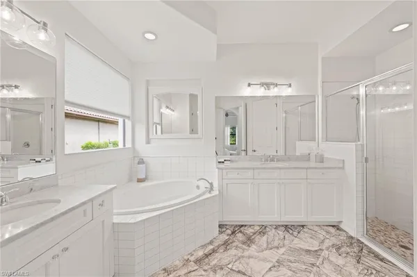a bathroom with a tub sink and mirror