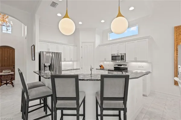 a kitchen with stainless steel appliances granite countertop a sink and a refrigerator