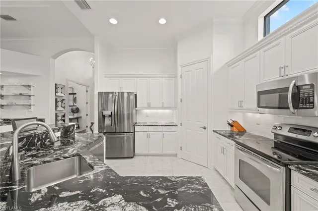 a kitchen with stainless steel appliances granite countertop a refrigerator sink and stove