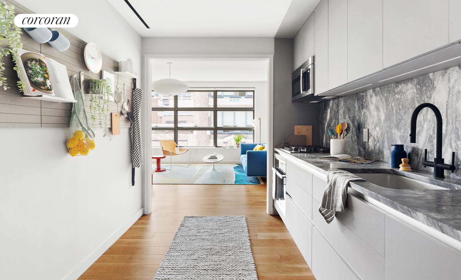 547 West 47th Street, Unit 405 Manhattan, NY 10036 - Photo 3 of 28 a kitchen with stainless steel appliances granite countertop a sink and cabinets