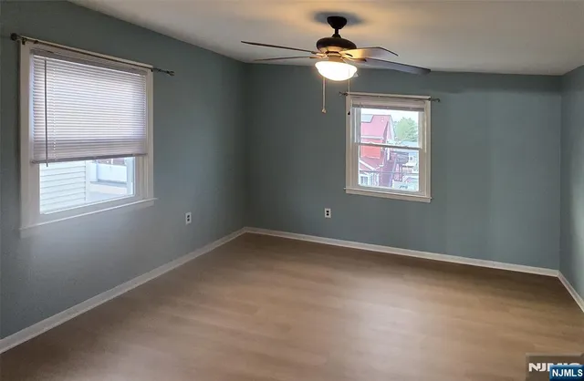 an empty room with windows and fan