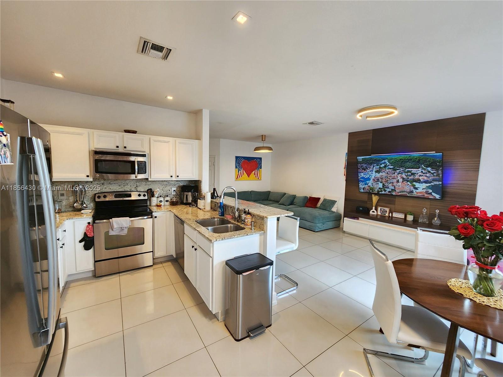 Ives Estates Miami, FL 33179 - Photo 6 of 28 a kitchen with stainless steel appliances kitchen island granite countertop a refrigerator and microwave