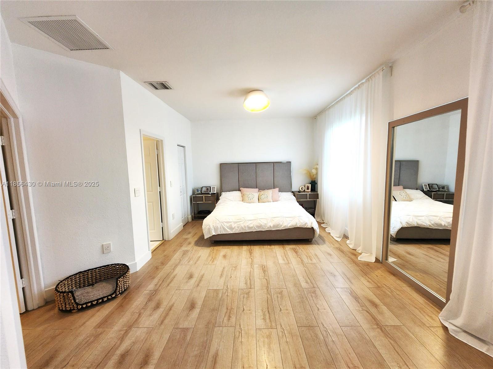 Ives Estates Miami, FL 33179 - Photo 8 of 28 a bedroom with a bed and a mirror