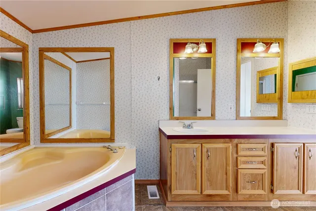 a bathroom with a tub sink and mirror