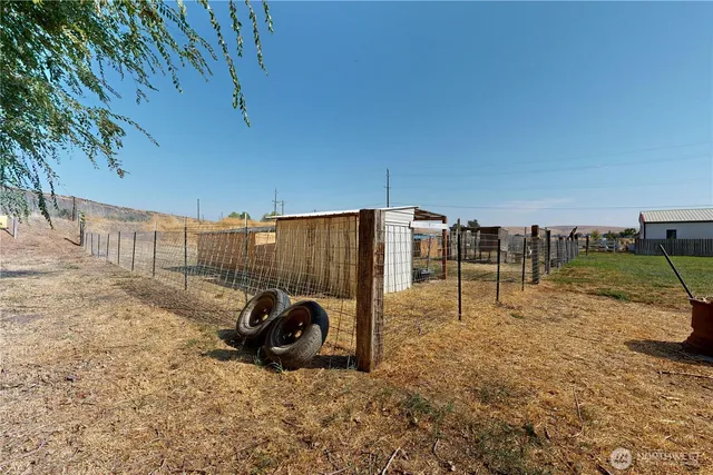 a view of a patio with a table and chairs under an umbrella