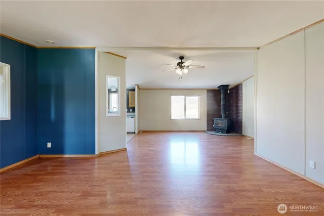 a view of an empty room with window and wooden floor