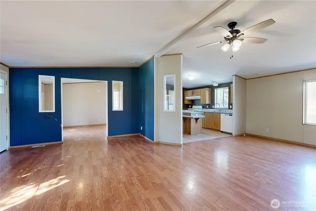 a view of an empty room with window and wooden floor