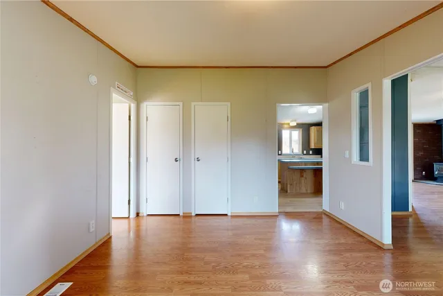 a view of empty room with kitchen and window