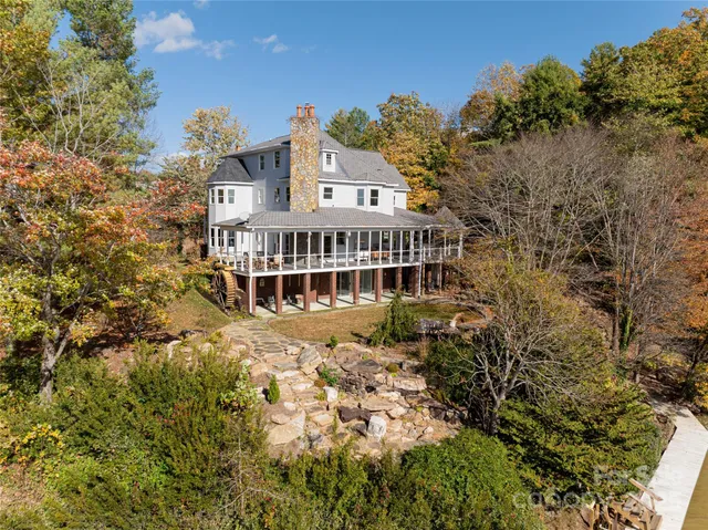 an aerial view of a house with yard and trees