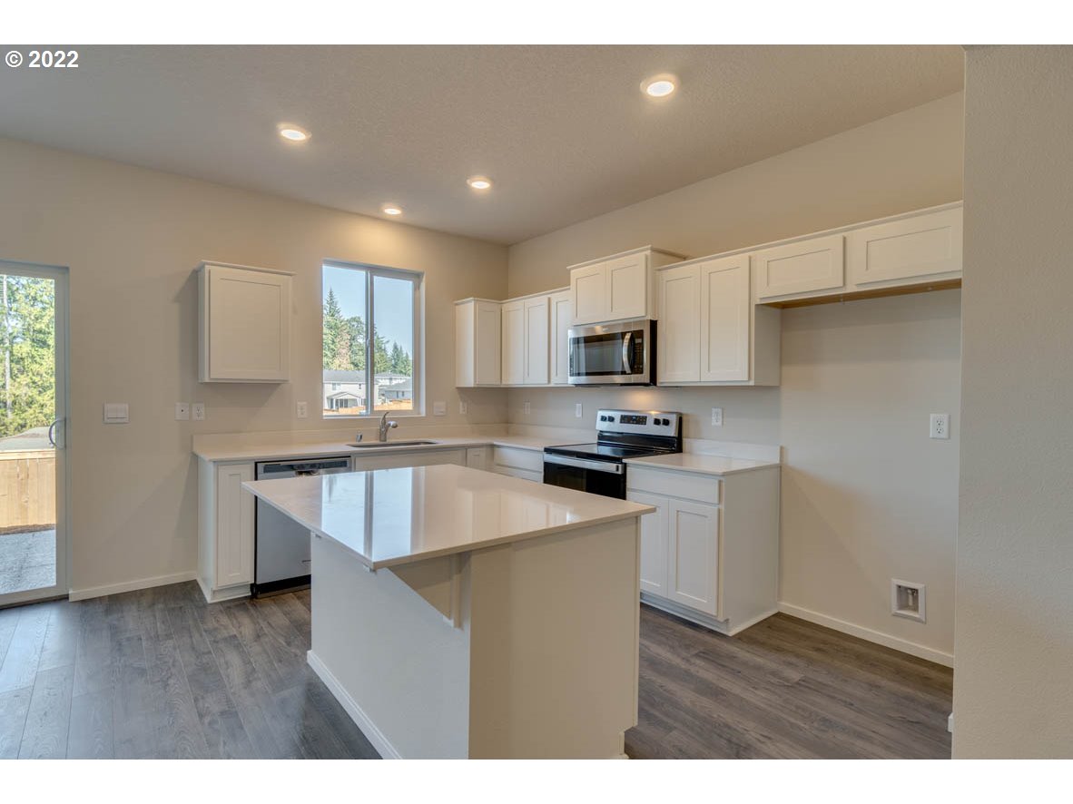 2731 North 2nd Way Ridgefield, WA 98642 - Photo 3 of 19 a kitchen with granite countertop white cabinets and white appliances