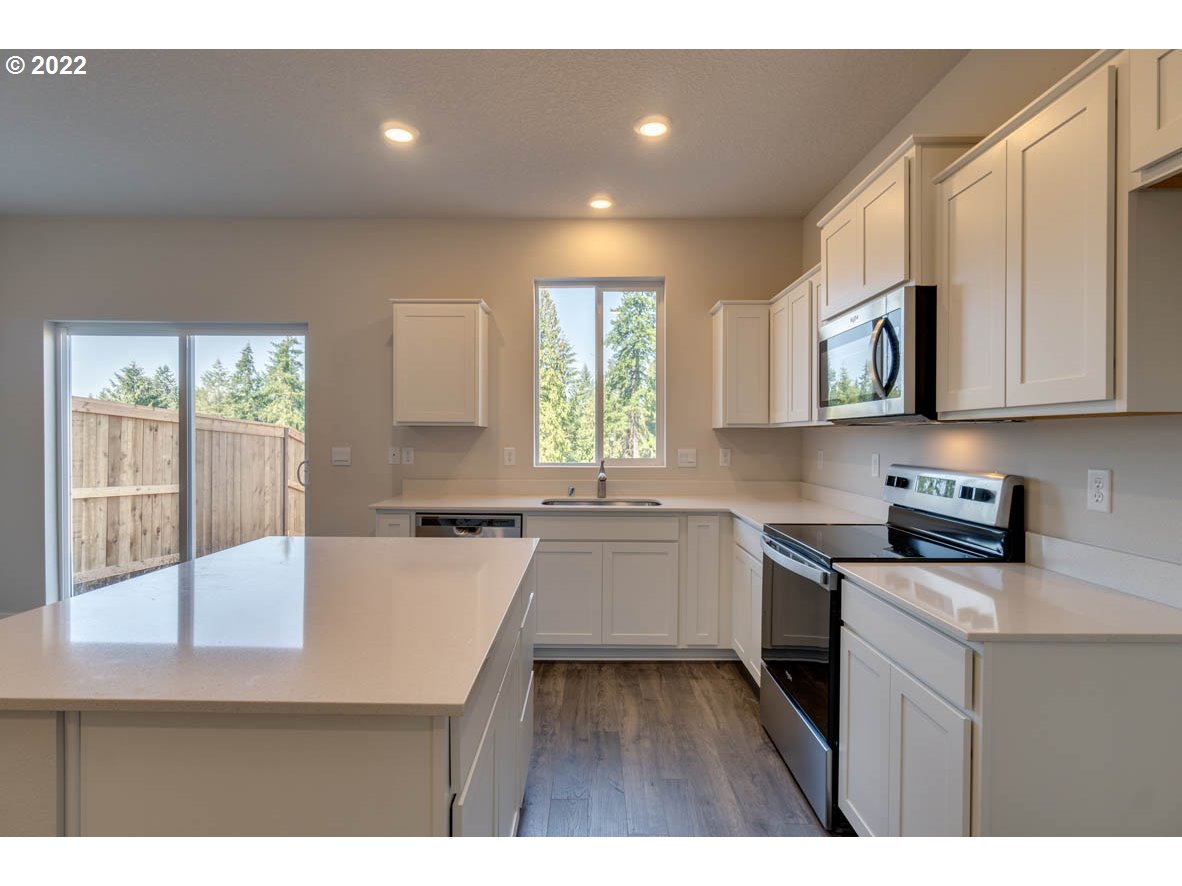 2731 North 2nd Way Ridgefield, WA 98642 - Photo 4 of 19 a kitchen with a stove a sink and a microwave