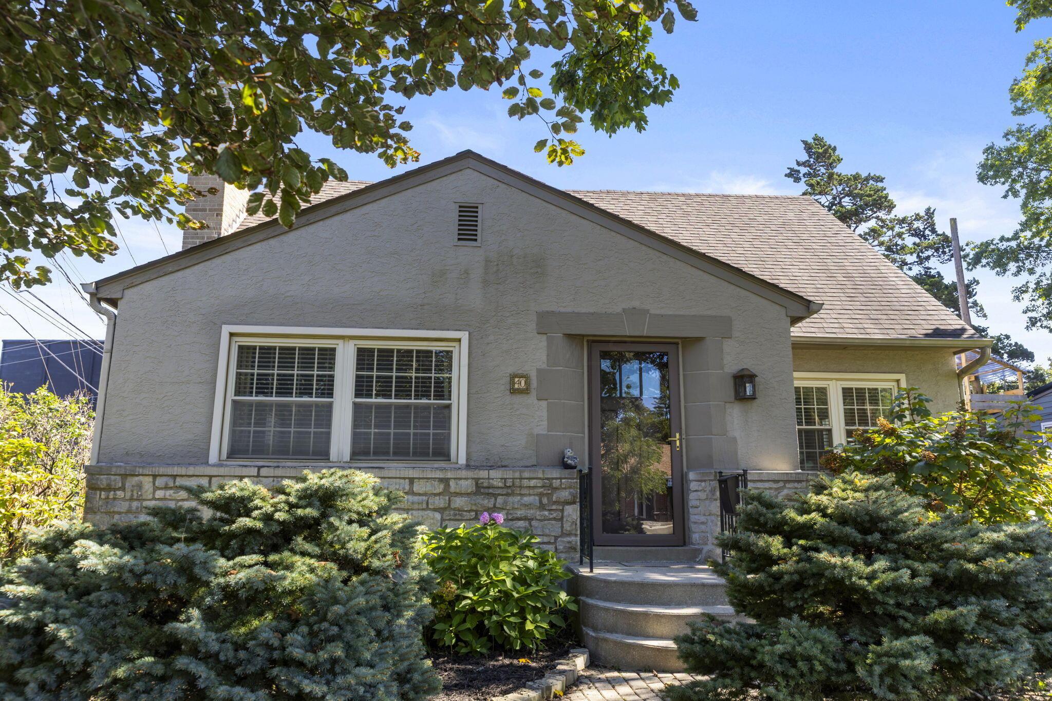 40 South Kellner Road Columbus, OH 43209 - Photo 42 of 57 Stucco exterior featuring a stone base, gabled roof, and a stone-framed entry with a dark door
