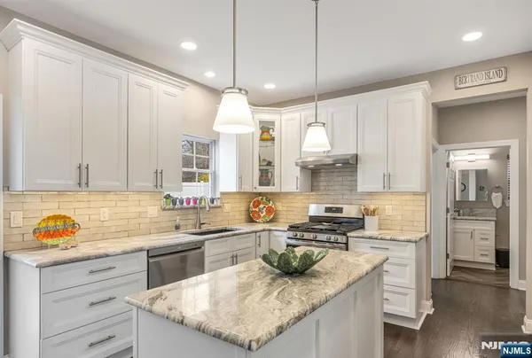 a kitchen with a sink a counter space appliances and cabinets