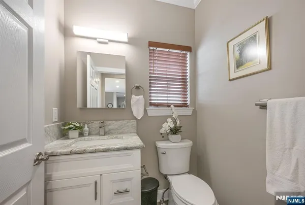 a bathroom with a granite countertop toilet sink and mirror