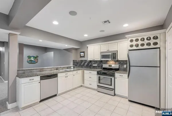 a kitchen with granite countertop cabinets stainless steel appliances and a dining table