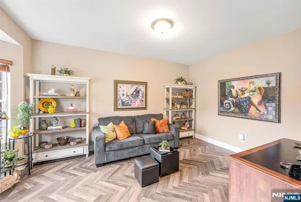 a living room with furniture and painting on the wall next to a window