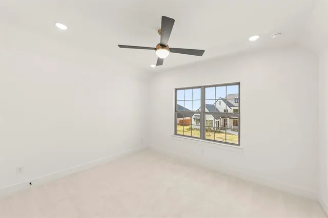 an empty room with windows and ceiling fan