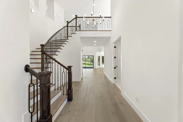 a view of staircase with wooden floor and a chandelier