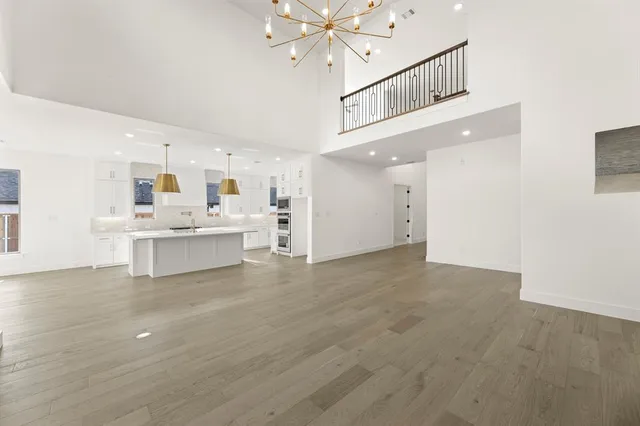 a view of an empty room with kitchen view and a window