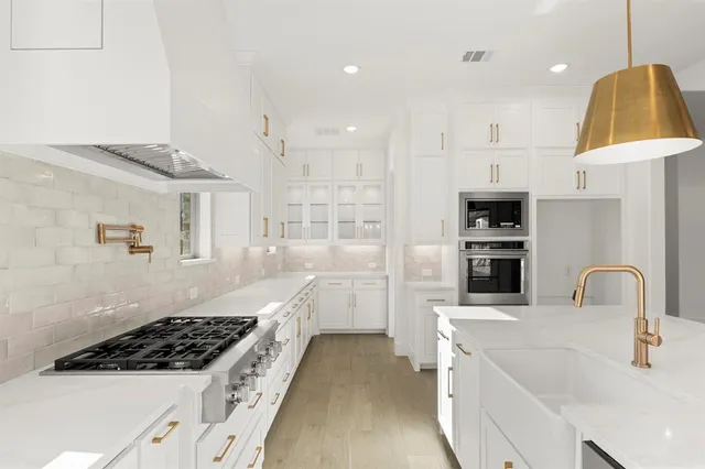 a kitchen with kitchen island stainless steel appliances a stove a sink and a refrigerator