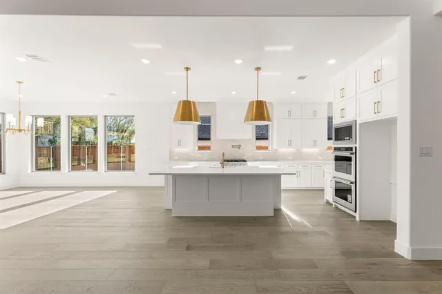 a large white kitchen with lots of counter space and appliances