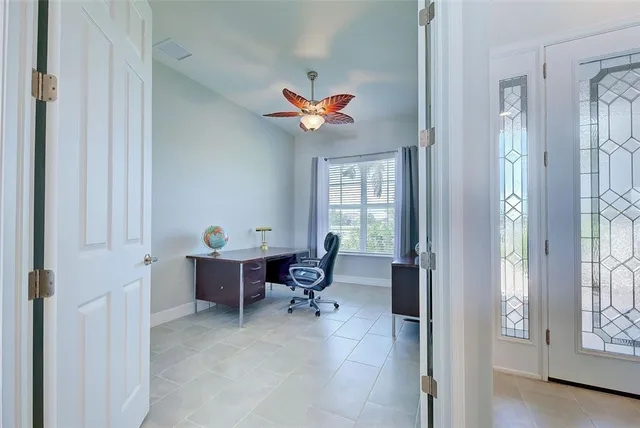 a living room with furniture a desk and chair with windows